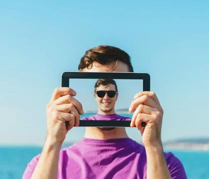 Man doing a self-portrait with him digital tablet Stock Photos