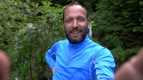 Man doing selfies with the waterfall behind him, slow motion shot at 240fps  Stock Footage 103509062
