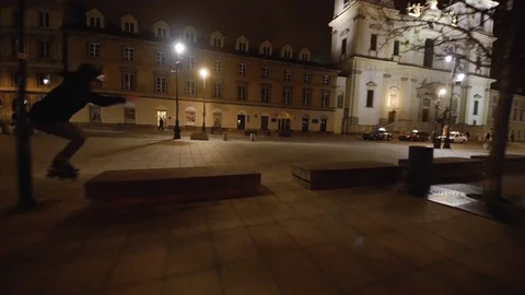 Man doing series of jumps on inline skates at night Stock Footage 120750069