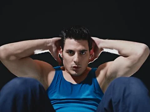 Man doing series of sit-ups on black background Stock Photos