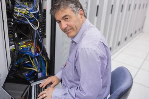 Man doing server maintenance with notebook Stock Photos