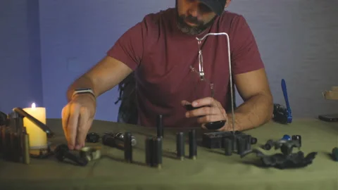 A man doing shotgun cartridges reloading with gun primers, shells, gunpowder Stock Footage 201296416