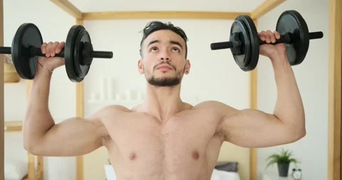 Man doing shoulder press exercise with dumbbells Stock Footage 156469823