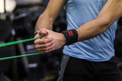 Man doing side-to-side chops exercise with elastic band at the gym. Stock Photos