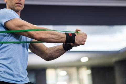 Man doing side-to-side chops exercise with elastic band at the gym. Stock Photos