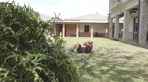 Man doing sit ups in a park Stock Footage 60260155