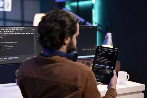 Man doing software quality assurance using tablet, reading source code Fotos Stock
