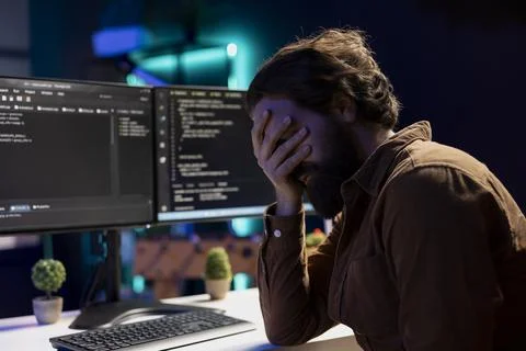 Man doing software quality assurance, reading source code on computer screen Stockfoto's