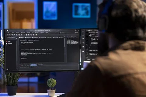 Man doing software quality assurance, reading source code on computer screen Stock Photos