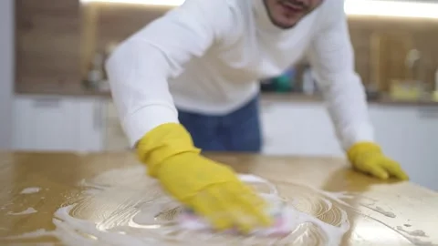 Man Doing Spring Cleaning Using Sponge with Foam to Wipe Table Stock Footage 328927409