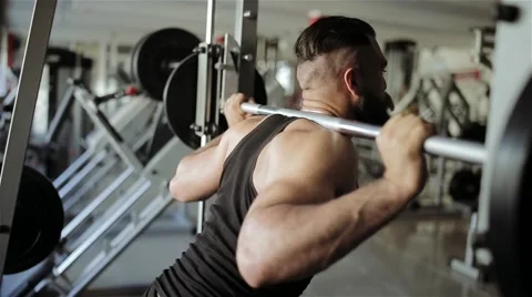 Man doing squats with a barbell in the gym Stock Footage 56635848