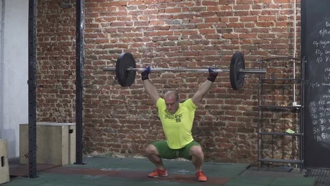 Man doing squats with a barbell in gym Stock Footage 72744735