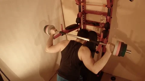 Man Doing Squats With a Barbell in Home Gym Stock Footage 62475780
