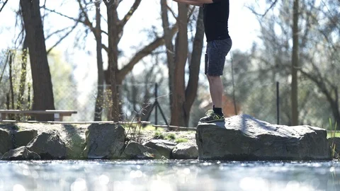 Man doing squats on the edge of a rock, stock video Stock Footage 105601967