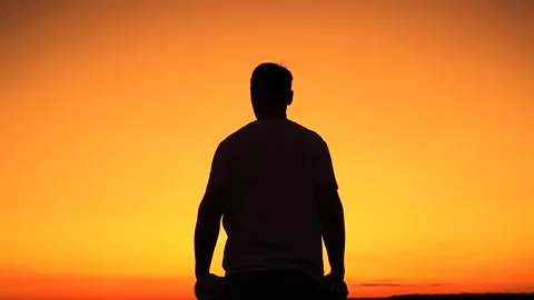 Man doing strength training, dumbbell lateral raise, nature, sunset, fitness Stock Footage 315912556
