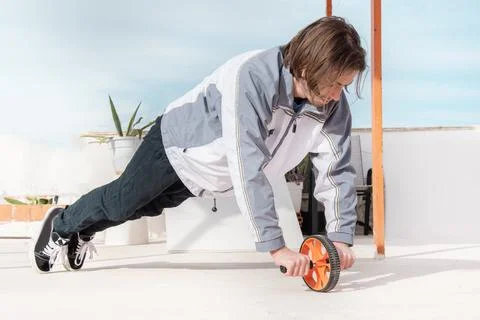 A man doing strength training exercises using a muscle strengthening wheel Stock Photos
