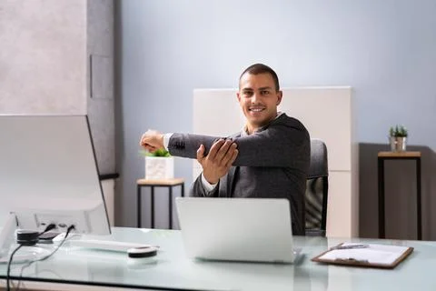Man Doing Stretching Exercise At Desk Working Stock Photos