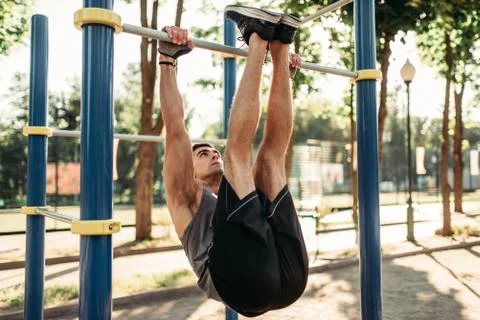Man doing stretching exercise using horizontal bar Stock-Fotos