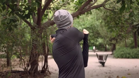 Man doing stretching exercises for arms in park Stock Footage 132050441