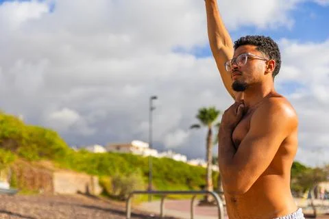 A man is doing stretching exercises while working out outdoors Stock Photos