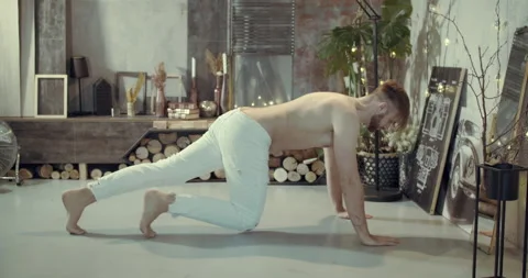 A man is doing stretching in his room Stock Footage 134680550