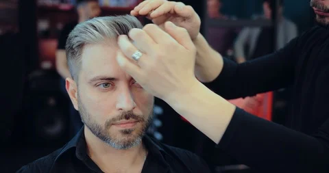 Man doing styling in a Barber shop. Stylist doing him hair styling. Portrait Stock Footage 105618549