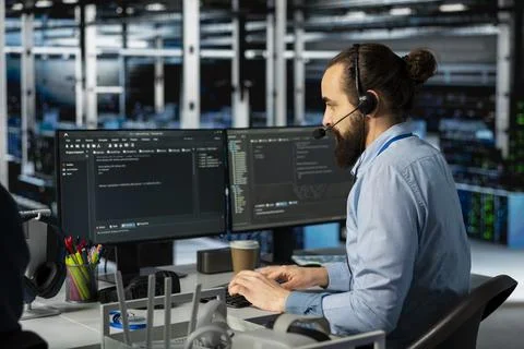 Man doing tech support in server room, managing large scale IT infrastructure Stock Photos