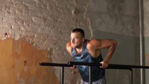 Man doing triceps dip on parallel bars in gym Video stock 136306815
