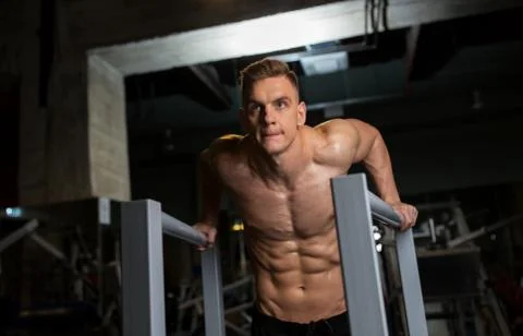 Man doing triceps dip on parallel bars in gym Stock-Fotos