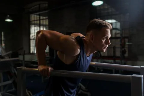 Man doing triceps dip on parallel bars in gym Stock Photos