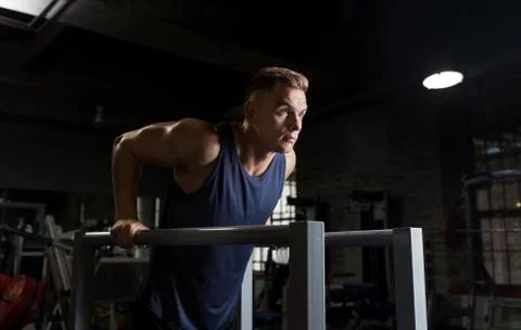 Man doing triceps dip on parallel bars in gym Stock Photos