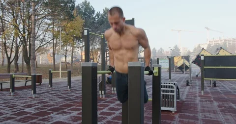 Man doing triceps dips  exercise in public park Stock Footage 121714984