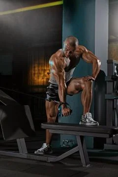 Man doing triceps exercise in the simulator Stock Photos