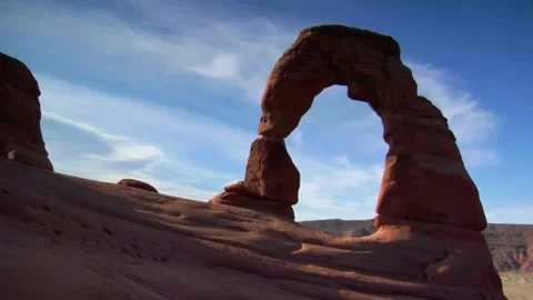A man doing a trick on a rock with Arches National Park in the background Stock Footage 156018609