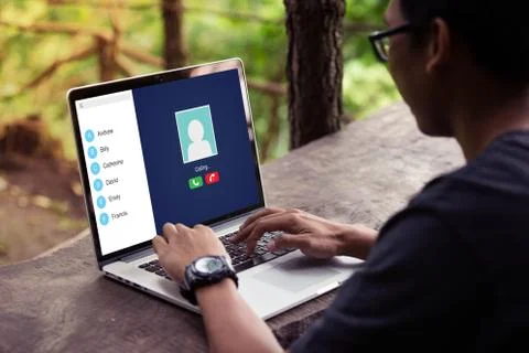 Man doing video call with his friend on the laptop / computer at the park / outd Stock Photos