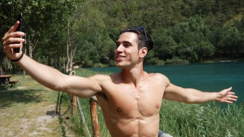 Man doing videochat at lake Stock Photos