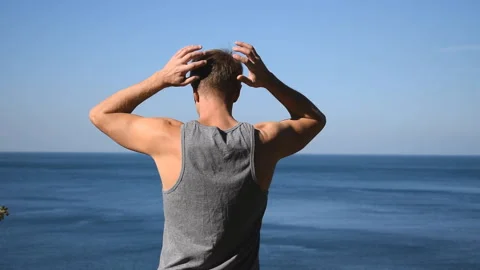 Man doing a warm-up exercise on the ocean. Fresh air and a healthy lifestyle 動画素材 96489180