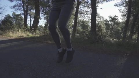Man doing warm up, knees up in the forest Stock Footage 163748851