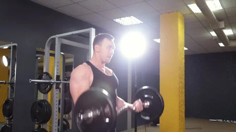 Man doing weight lifting in gym Stock Footage 68077744