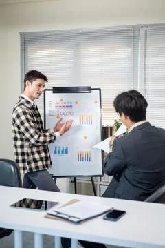 A man doing work presentation on white board and businessman boss reading d.. Stock Photos