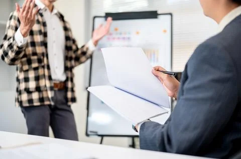 A man doing work presentation on white board and businessman boss holding d.. Stock Photos
