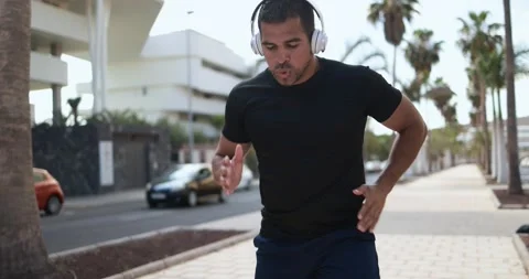 Man doing workout in the city while listening music Stock Footage 154194144