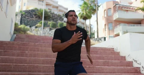 Man doing workout in the city while listening music Stock Footage 154194256