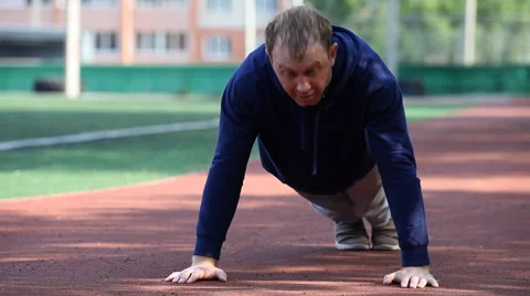 Man doing workout in an outdoor stadium. Morning gymnastics Stock Footage 68938354