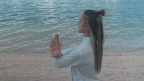 Man doing yoga on the beach on the blue sky background Stock Footage 87542553