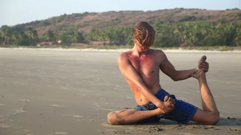 Man doing Yoga on the beach Stock Footage 56233374