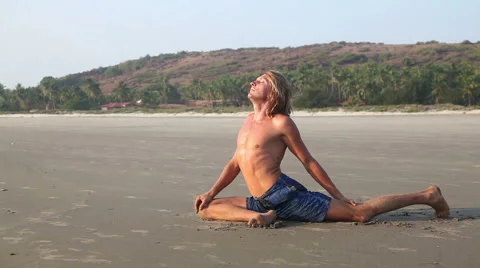Man doing Yoga on the beach Stock Footage 56233803
