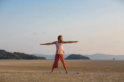 Man is doing yoga on the beach Stock Photos