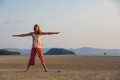 Man is doing yoga on the beach Stock Photos