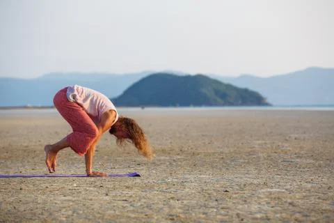 Man is doing yoga on the beach Stockfoto's